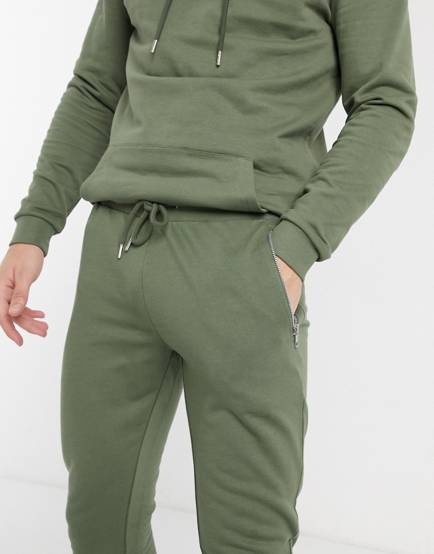ASOS DESIGN - Organisch superskinny joggingbroek in kaki met zakken met zilveren ritsen-Groen