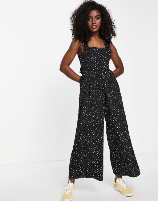ASOS DESIGN - Overgooier-jumpsuit met gekruiste bandjes met ruches aan de achterkant en stippenprint in zwart-wit