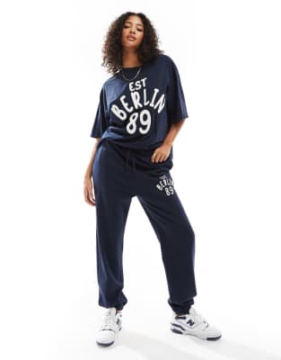 ASOS DESIGN - Oversize-Jogginghose in Marineblau mit Bündchen und „Berlin"-Applikationsprint, Kombiteil