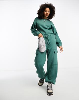 ASOS DESIGN - Oversize-Jumpsuit aus Sweatshirt-Stoff in Khaki mit Taschen-Grün