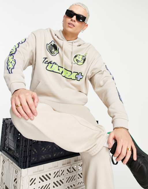 ASOS DESIGN – Oversize-Kapuzenpullover in Beige mit Motocross-Prints