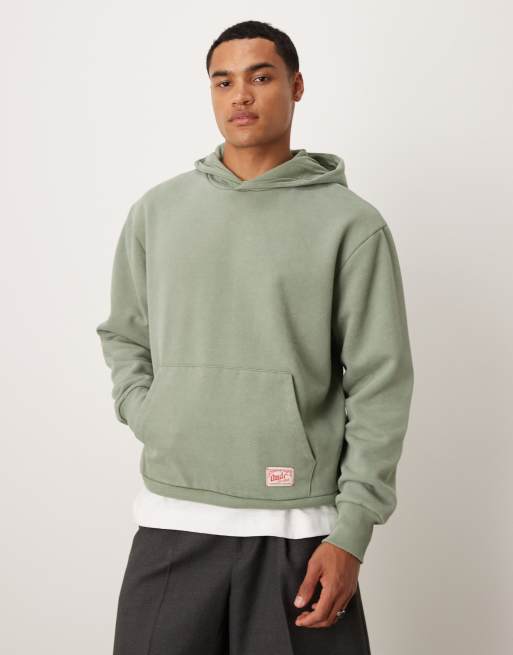ASOS DESIGN – Oversize-Kapuzenpullover in verwaschenem Grün mit gewebtem Etikett-Detail
