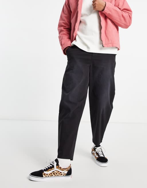 ASOS DESIGN - Oversized chino met smaltoelopende pasvorm in zwart afgewerkt met pigmentspray
