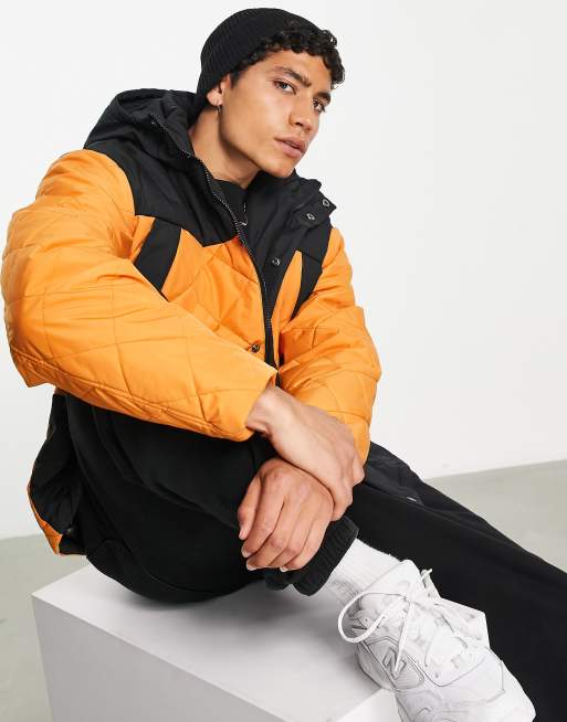 ASOS DESIGN - Oversized gewatteerd regenjack met capuchon in oranje en zwart