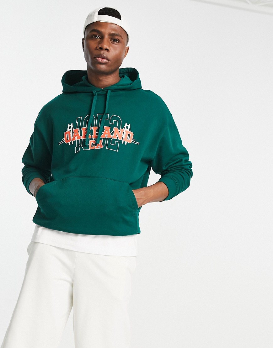 ASOS DESIGN oversized hoodie in dark green with varsity Oakland print