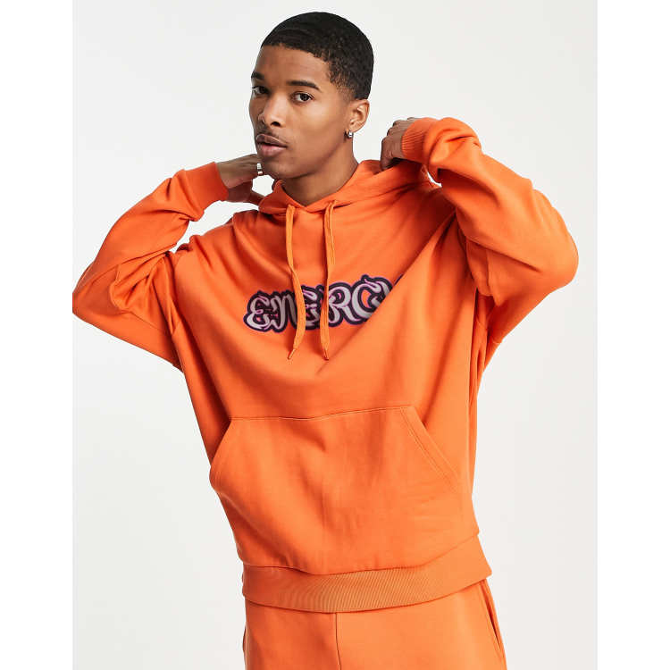 ASOS DESIGN oversized hoodie in orange with energy text print part of a set