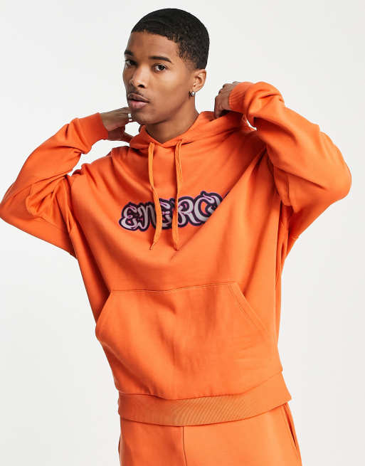 ASOS DESIGN oversized hoodie in orange with energy text print part of a set