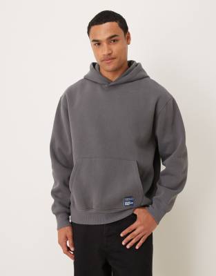 ASOS DESIGN oversized hoodie with woven label badge in acid washed charcoal-Gray