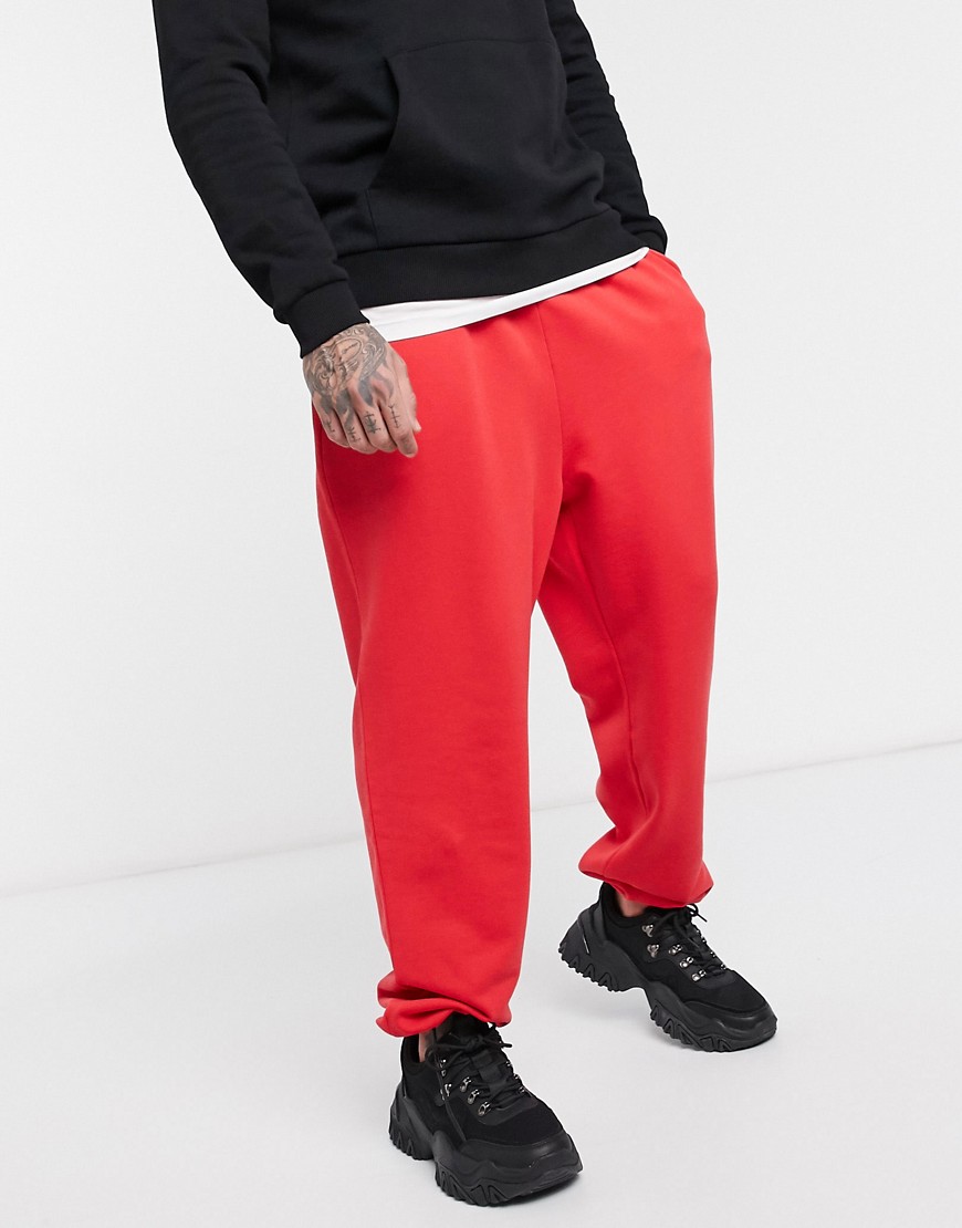 ASOS DESIGN oversized joggers in red with toggle hem