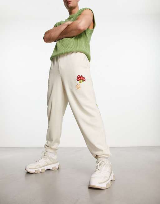 ASOS DESIGN - Oversized joggingbroek in beige met verspreide borduursels