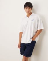 ASOS DESIGN boxy oversized polo shirt with cut and sew paneling and city graphics in cream