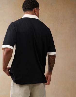 ASOS DESIGN oversized polo with cut and sew paneling and sports graphics in black