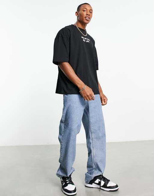 Black oversized T-shirt with light-wash baggy jeans and black-and-white sneakers