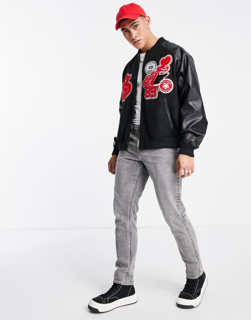 ASOS DESIGN oversized varsity bomber jacket in black with purple badging