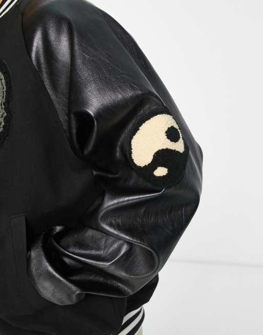 ASOS DESIGN varsity jacket in black with faux leather sleeves