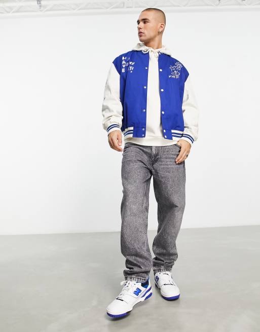 ASOS DESIGN oversized varsity jacket with badges in blue