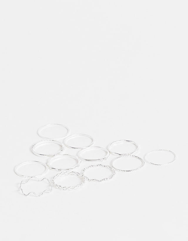 ASOS DESIGN pack of 12 rings with twist details and engraved designs in silver tone