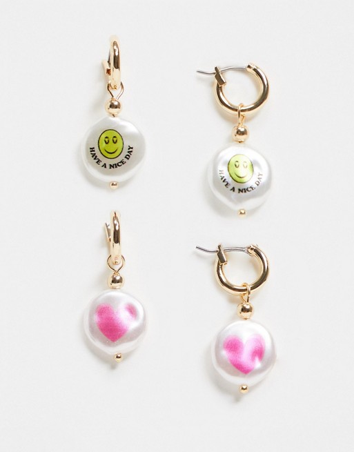 ASOS DESIGN pack of 2 hoop earrings with printed happy face and heart pearls in gold tone