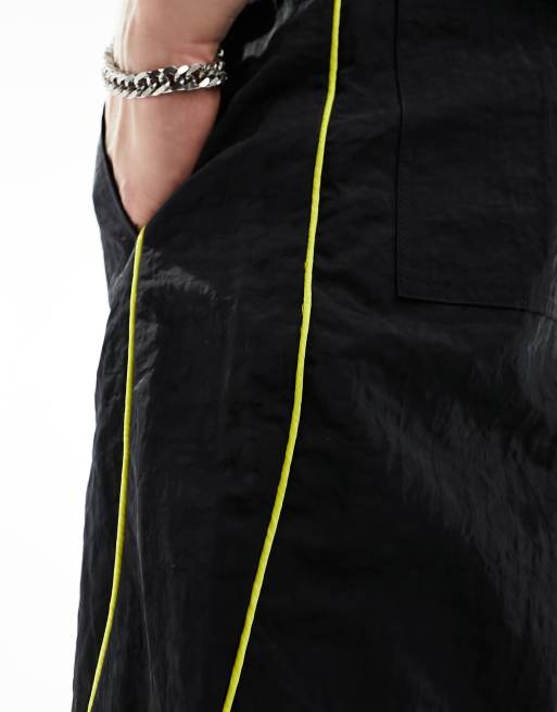 ASOS DESIGN paneled piping track pants in black and yellow sheen nylon, 2 of 5