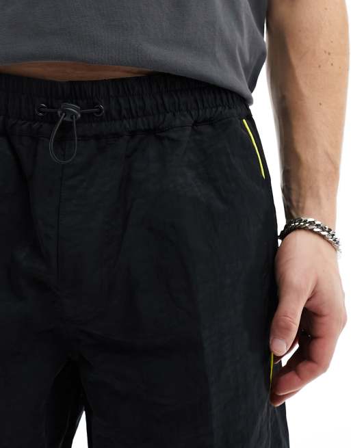ASOS DESIGN panelled piping track pants in black and yellow sheen nylon, 5 of 5