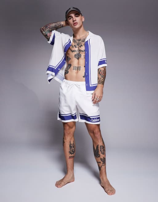 ASOS DESIGN - Pantaloncini da bagno di media lunghezza bianchi con scritta stampata in coordinato