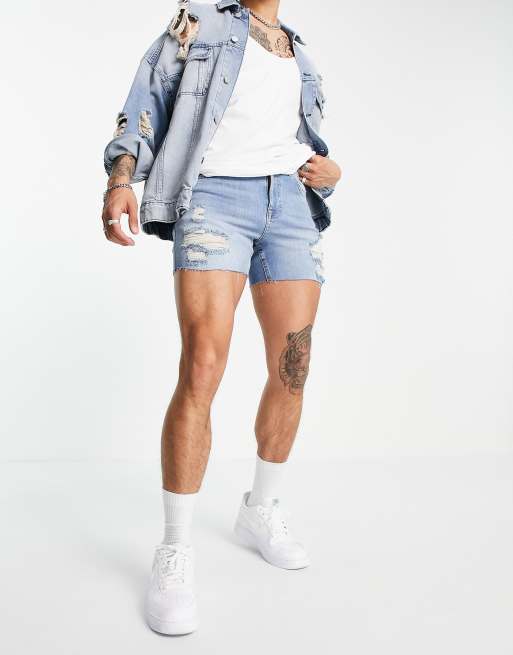 ASOS DESIGN - Pantaloncini di jeans skinny corti lavaggio blu medio con strappi e orlo grezzo