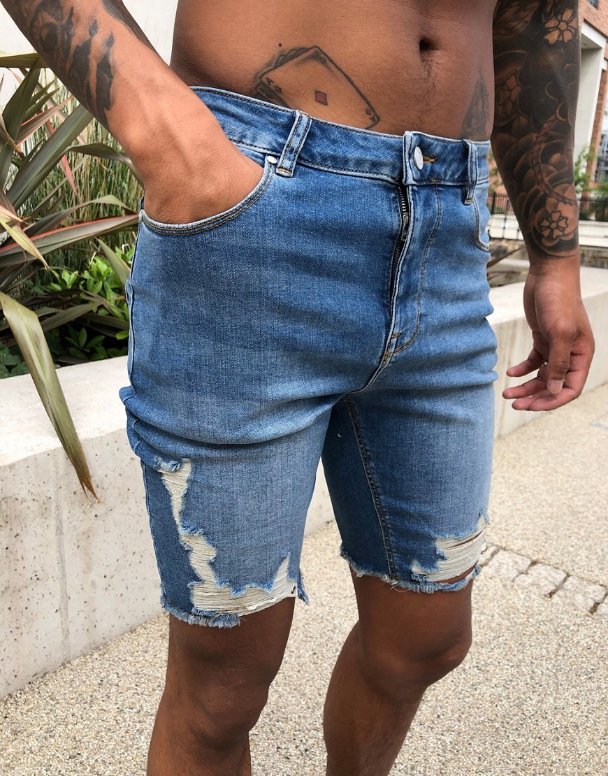 ASOS DESIGN - Pantaloncini di jeans skinny power stretch lavaggio medio con fondo grezzo e strappi effetto smagliato-Blu