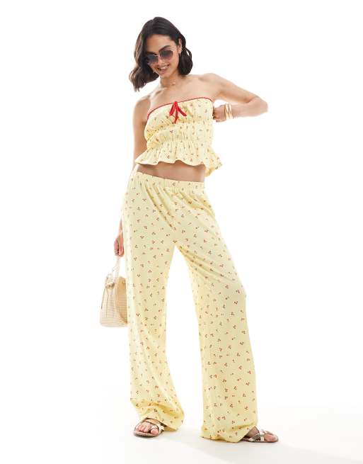 ASOS DESIGN - Pantaloni a fondo ampio color latticello con stampa di ciliegie in coordinato