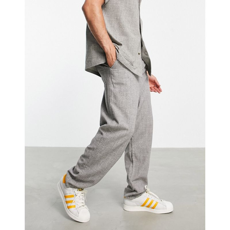 Coordinati Uomo DESIGN - Pantaloni affusolati oversize in tessuto grigio con trama in coordinato