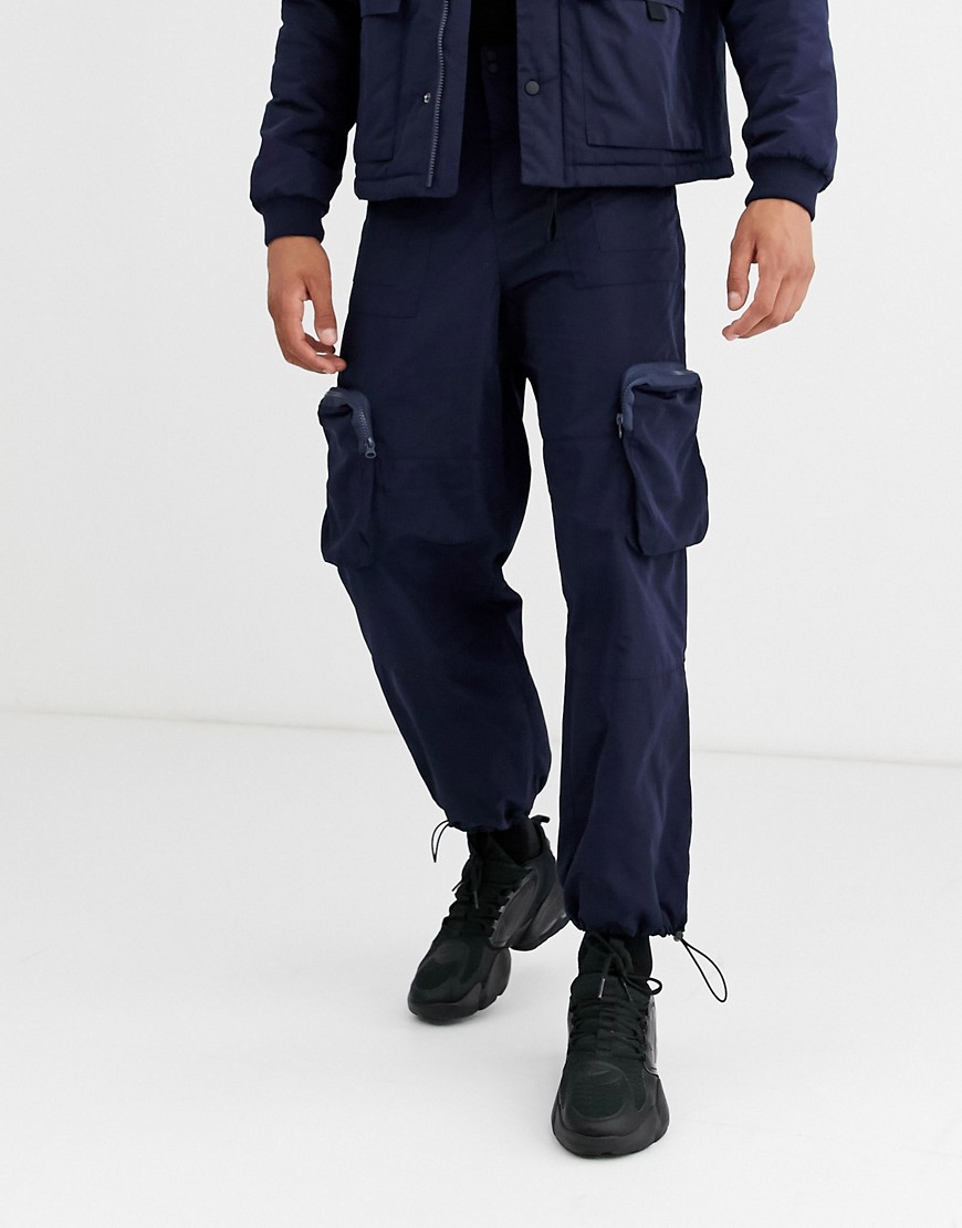 ASOS DESIGN - Pantaloni cargo tech blu navy con tasche 3D in coordinato