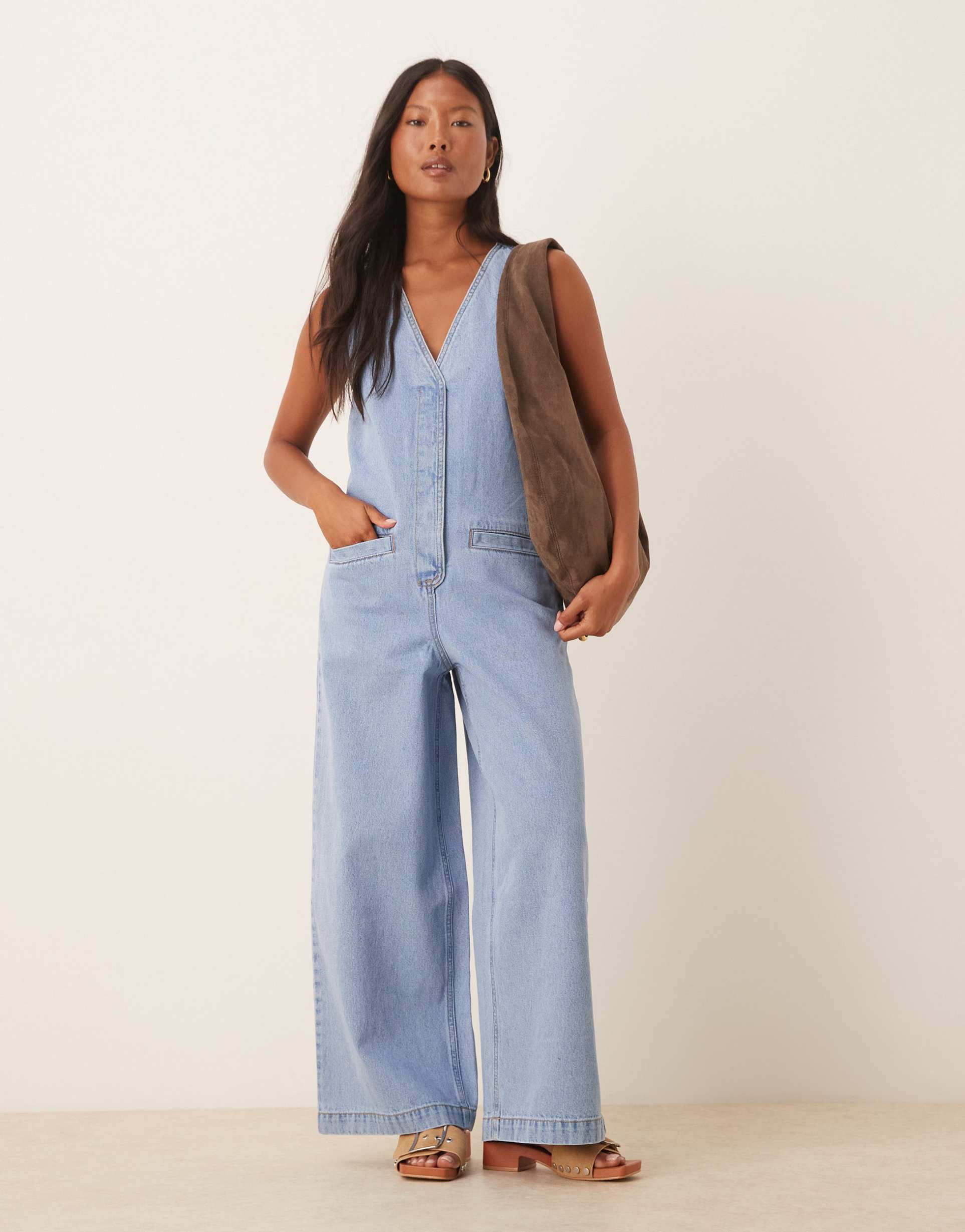 asos design petite denim sleeveless jumpsuit with tie back in light wash blue