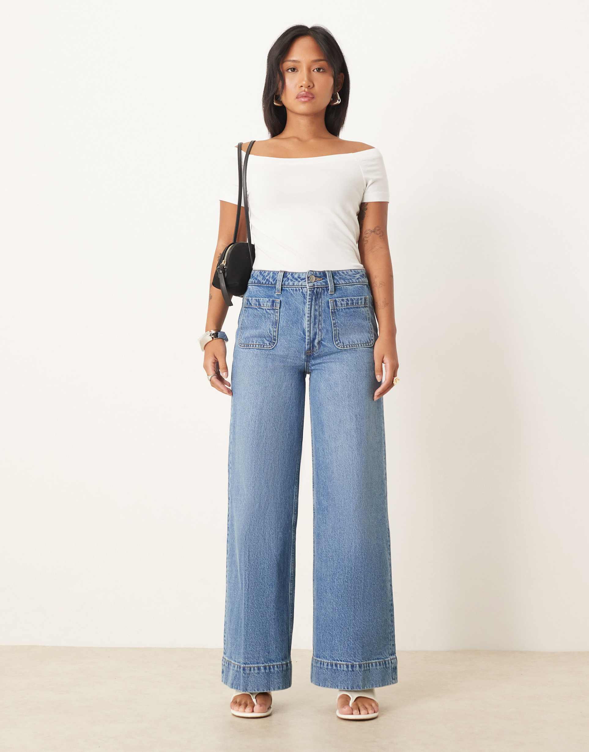 asos design petite high rise wide leg jeans with front pockets in mid blue