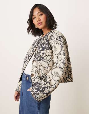 ASOS DESIGN Petite - Kragenlose Cropped Steppjacke mit schwarz-weißem Blumenmuster-Bunt