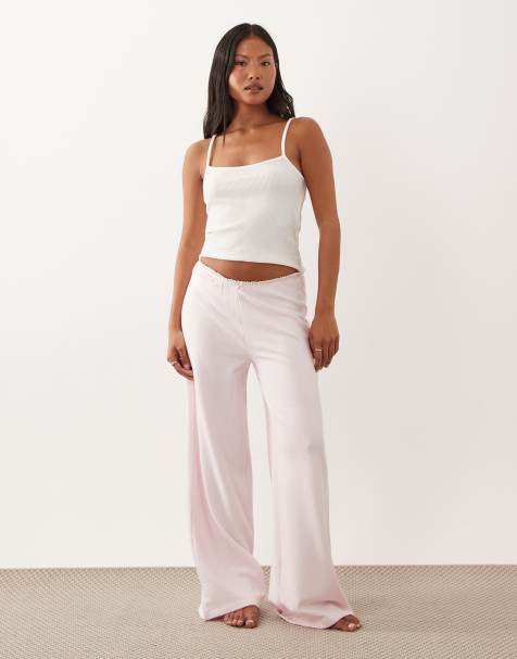 ASOS DESIGN Petite - Pyjamabroek van zachte jersey met wijde pijpen en bloempje aan de rand in zachtroze - view 1