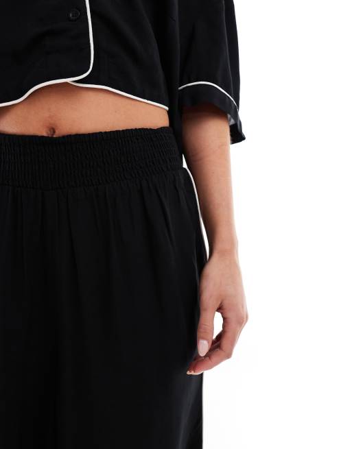 ASOS DESIGN Petite super soft slinky wide leg pajama pants in black with contrast binding