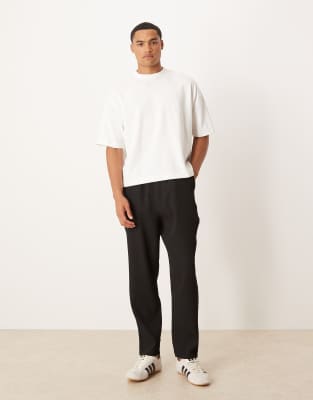 ASOS DESIGN plisse tapered trousers in black - view 1