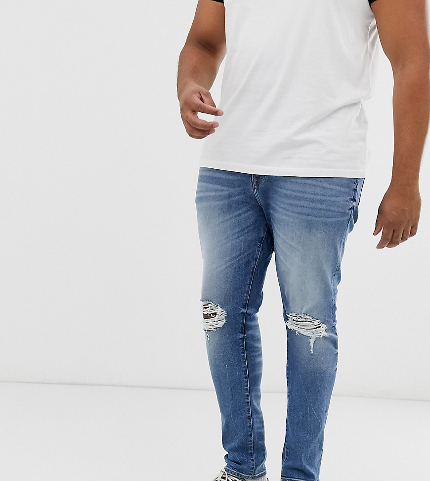 ASOS DESIGN Plus 12.5oz super skinny jeans in mid wash blue with busted knees