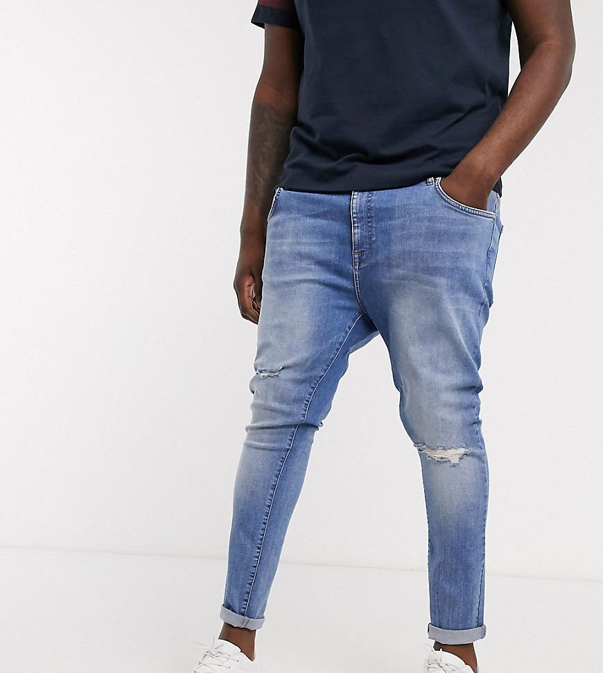ASOS DESIGN Plus - Jeans power stretch lavaggio blu medio con strappi sulle ginocchia ed effetto spray