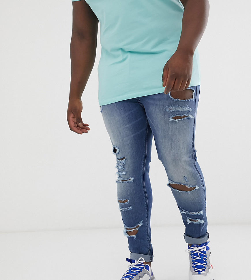 ASOS DESIGN Plus - Superstrakke jeans met powerstretch en grote scheuren in mid wash blauw