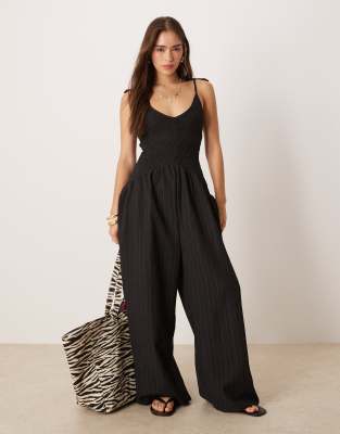 ASOS DESIGN - Polyester-Jumpsuit in Schwarz mit V-Ausschnitt, Knitterstruktur und tiefer Taille