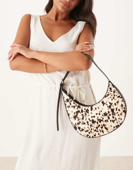 ASOS DESIGN pony hair asymmetric scoop shoulder bag with buckle detail in cow print