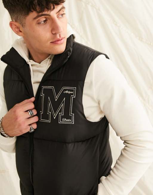 ASOS DESIGN puffer vest with varsity badge in black