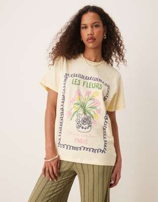 ASOS DESIGN - Regulär geschnittenes T-Shirt in verwaschenem Zitronengelb und Fleurs-Grafik