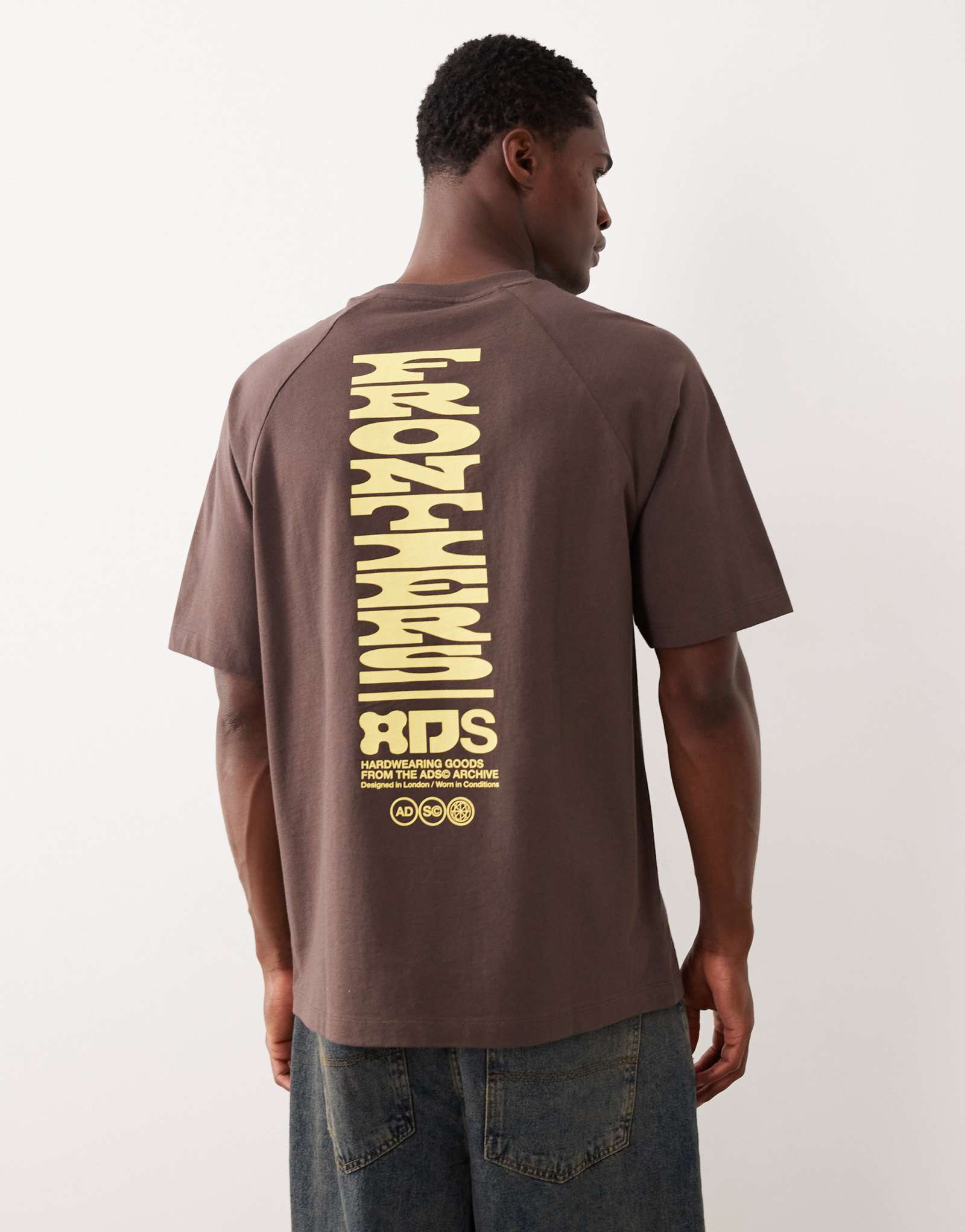 ДИЗАЙНЕРСКАЯ футболка реглан свободного кроя ASOS DESIGN с текстовой графикой коричневого цвета