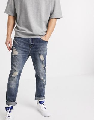 ASOS DESIGN relaxed tapered jeans in dark wash blue with heavy rips