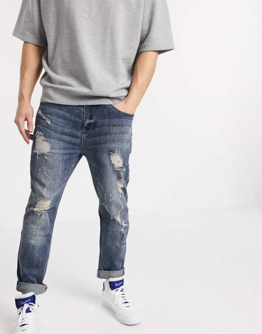 ASOS DESIGN relaxed tapered jeans in dark wash blue with heavy rips | ASOS