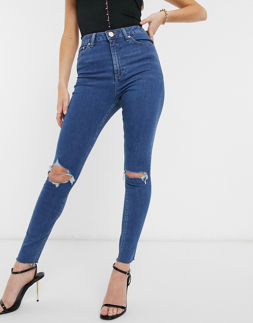 ASOS DESIGN - Ridley - 'Skinny' jeans met hoge taille en onafgewerkte zoom met felle medium wassing-Blauw