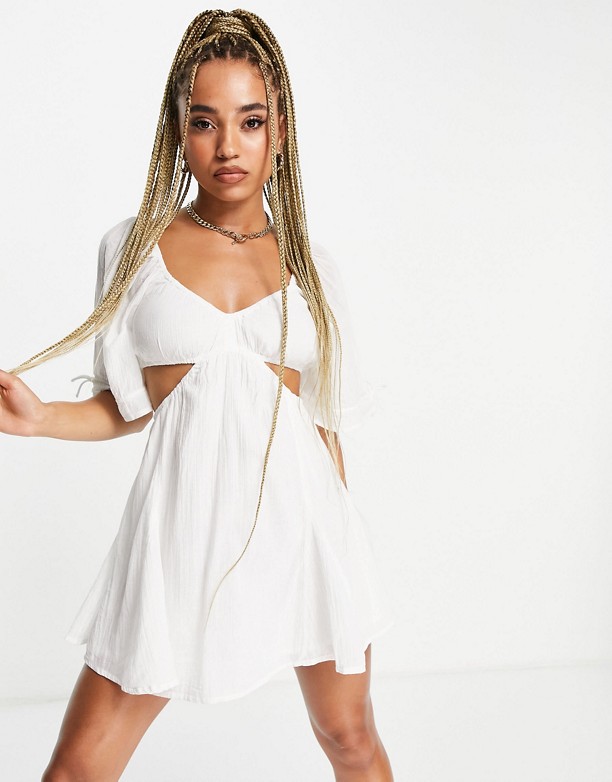  Kup Najlepsze ASOS DESIGN – Rozkloszowana biała letnia sukienka mini z wycięciami po bokach i wiązaniem Biały