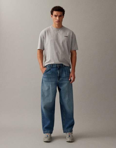 ASOS DESIGN - Ruimvallende toelopende jeans met plooien in mid-wash blauw - view 1