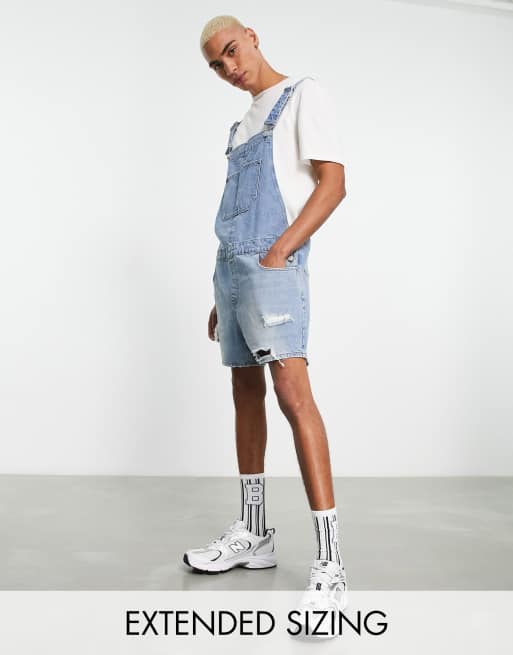 ASOS DESIGN - Salopette courte en jean avec déchirures - Bleu moyen délavé